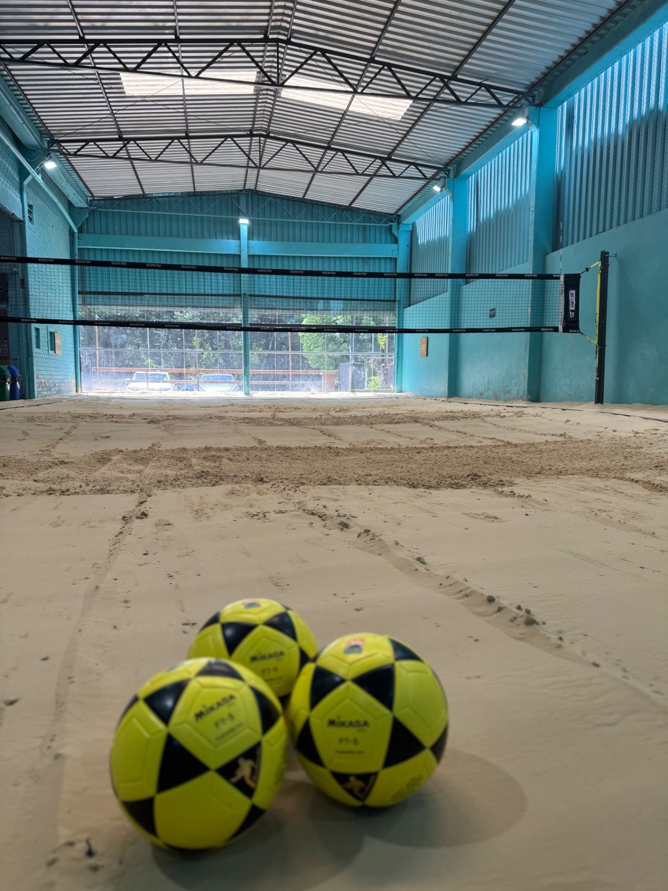 Quadra coberta com bolas Mikasa de futevôlei
