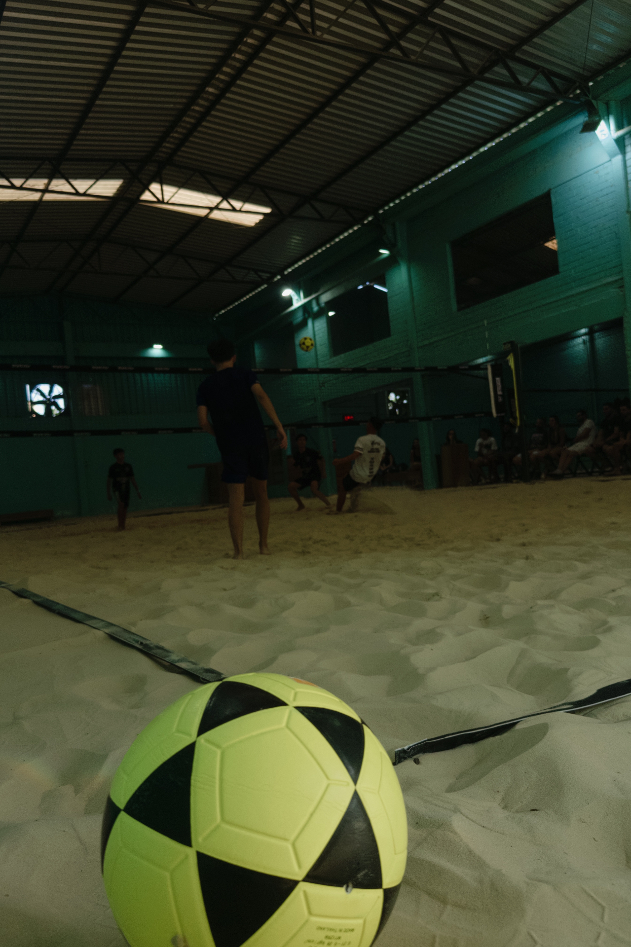 Jogo noturno em andamento na quadra de areia